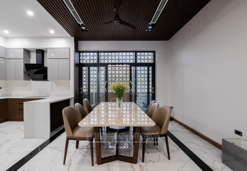 Việc thi công hoàn thiện nội thất phòng ăn của biệt thự 4 tầng tại Nghệ An được thực hiện với bộ bàn ghế ăn hiện đại và sang trọng. Bàn ăn mặt đá chân gỗ tự nhiên được kết hợp với bộ 6 ghế ăn gỗ óc chó bọc da cao cấp.